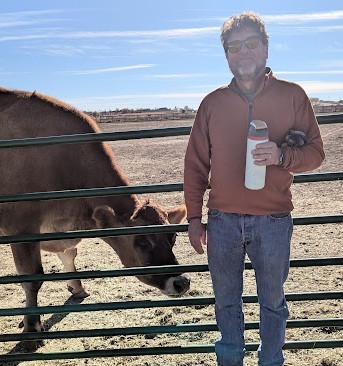 John holding a baby goat at a sanctuary